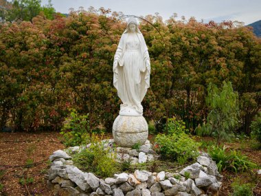 Statue in the garden of Saint Francis Friary and Church in Cres (Croatia), cloudy day in springtime