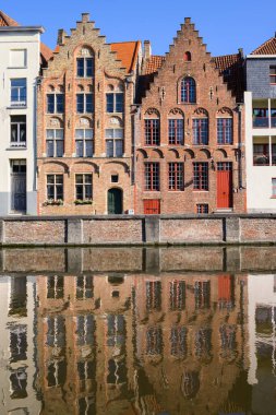 Brugge, Belgium - July 4, 2022: Reflection of colorful houses at Langerei on a sunny day in summer