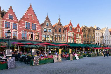 Brugge, Belgium - July 4, 2022: Restaurants in Grote Market of Bruges, sunny evening in summer