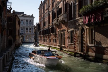 Venice, Italy - October 30, 2021: Canal with taxi boat on Venice on a sunny day in autumn, old palace