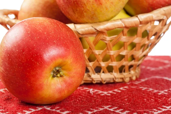 红色桌布上的柳条篮中的红苹果 — 图库照片