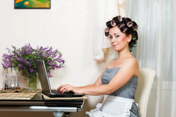 Huisvrouw in de eetzaal met laptop — Stockfoto