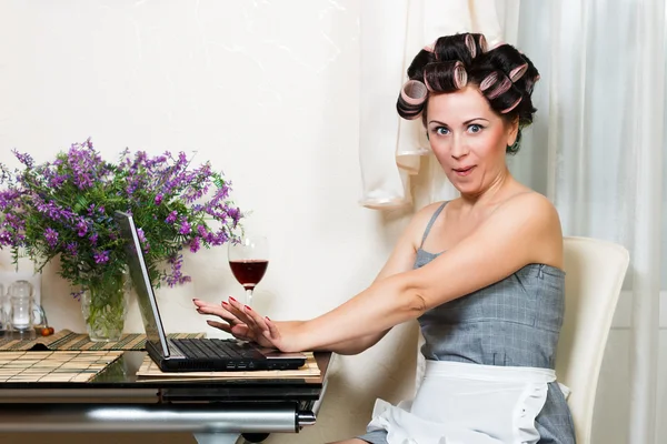 Домохозяйка в столовой с ноутбуком и красным вином Стоковое Фото