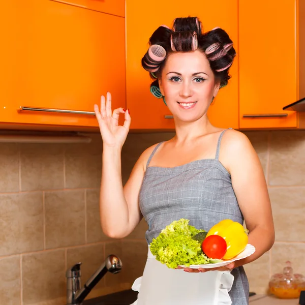 Beautiful woman in the kitchen with vegetables plate — Φωτογραφία Αρχείου