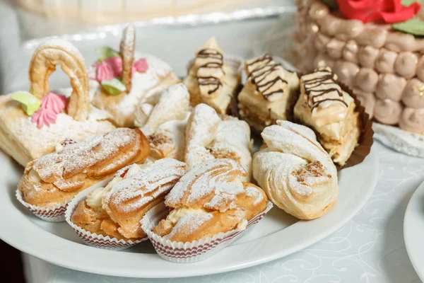 Eclairs doces com creme de açúcar em pó polvilhado Fotografia De Stock