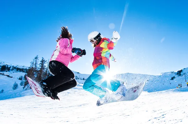 Two girls having great deal of fun jumping and riding boards — Stock Photo, Image