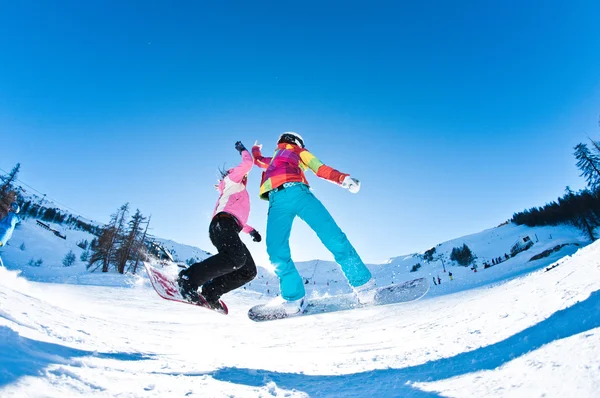 Two girls having great deal of fun jumping and riding boards Stock Picture