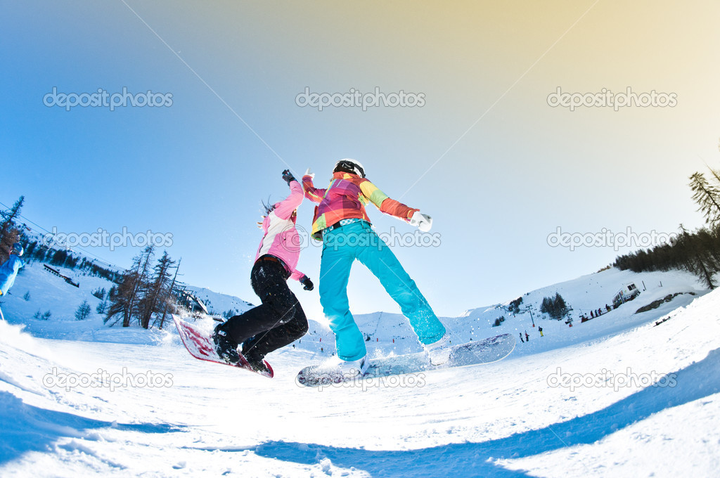 Two girls having great deal of fun jumping and riding boards