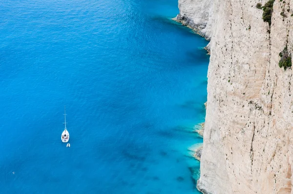 Small yacht cruising near white sea cliffs — Stock Photo, Image