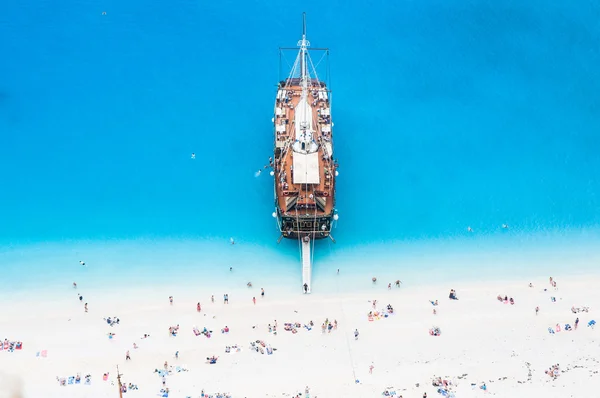 Large sail cruise ship anchored at white sand beach, seen from above — Stock Photo, Image