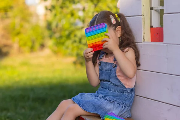 Criança brincando com pop-lo, pressionando as bolhas com os dedos, vista superior.Novo brinquedo antistress para crianças e adultos.Espaço de cópia para texto ou design. — Fotografia de Stock