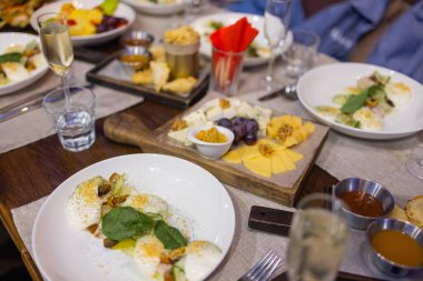 Güzel yaz çiçekleriyle süslenmiş abur cuburlarla dolu yemek masası. Yemek Masası Lezzetli Organik Yemekler Konsepti. Misafiri bekliyoruz..