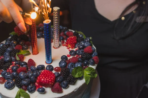 Τούρτα γενεθλίων με κεριά. Κεριά στην τούρτα. Τούρτα για διακοπές. Όμορφο λευκό κέικ με φράουλες σε σκούρο φόντο. Κάθετη φωτογραφία. — Φωτογραφία Αρχείου