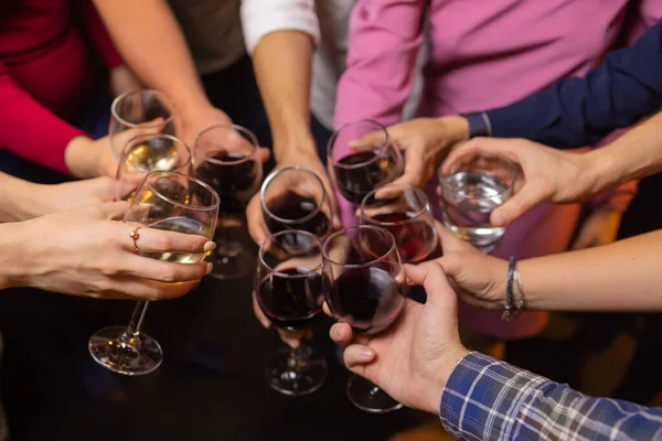 Celebración. Gente sosteniendo copas de vino blanco haciendo un brindis. — Foto de Stock