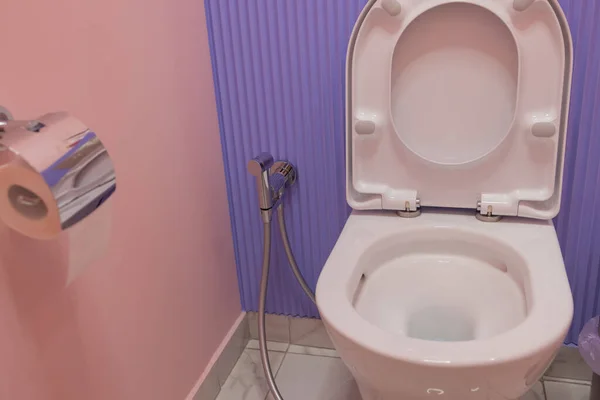 Modern ceramic toilet bowl near color wall in restroom. — Stock Photo, Image