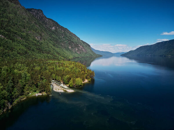 Landscape with boats in the water lake with views of the mountains. Teletskoye Lake Altai in Siberia.