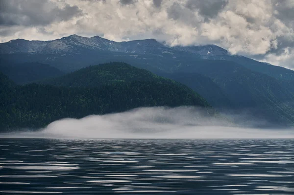 Niebla en el valle de la montaña. Niebla matutina sobre el lago en las montañas Altai . — Foto de Stock