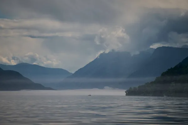 Nevoeiro no vale da montanha. Nevoeiro matutino sobre o lago nas montanhas de Altai . — Fotografia de Stock