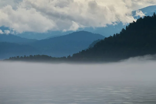 Niebla en el valle de la montaña. Niebla matutina sobre el lago en las montañas Altai . — Foto de Stock