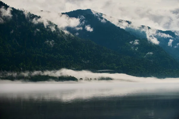 Nevoeiro no vale da montanha. Nevoeiro matutino sobre o lago nas montanhas de Altai . — Fotografia de Stock