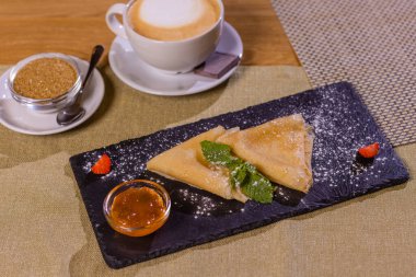 Krep, hamurdan yapılan düz ve yuvarlak un ürünleri, tavada kızartılarak, gri bir zemin üzerinde siyah bir tabakta uzanıyorlar. Pankekler bağımsız bir yemek olarak ve dolgularla birlikte kullanılır..