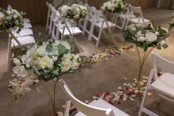 Праздничное оформление свадебного торжества в банкетном зале с белыми скатертями и цветами. — стоковое фото