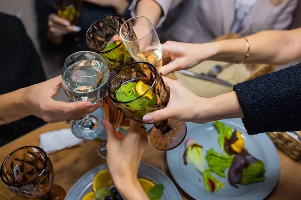 Świętowanie. Ludzie trzymający kieliszki białego wina wznoszącego toast. — Zdjęcie stockowe