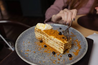 Beyaz tabakta nane ve bademlerle süslenmiş katmanlı ballı Rus Medovik keki..