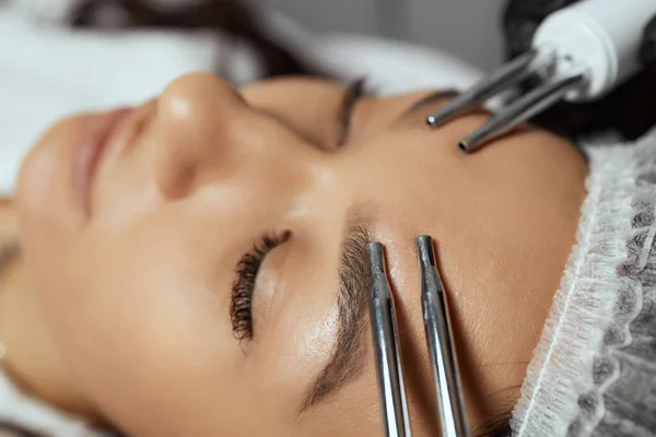 Косметологія. Красива жінка в СПА клініці Прийом стимулюючого електричного лікування обличчя від терапевта . — стокове фото