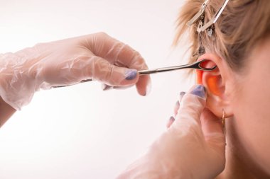 Profesyonel top ile kulak piercing mücevher yerleştirerek. Tragus türü.