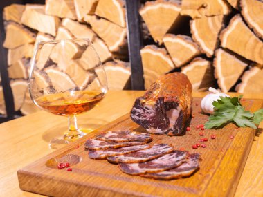 Ahşap bir masada dilimlenmiş tütsülenmiş tavla taze otlar ve aromatik baharatlar ilave edilir..