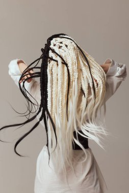 Beyaz arka planda siyah afrokolar olan genç bir kadın..