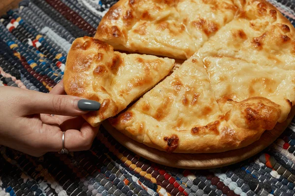 Khachapuri on the table. Top view female hand. — Stock Photo, Image