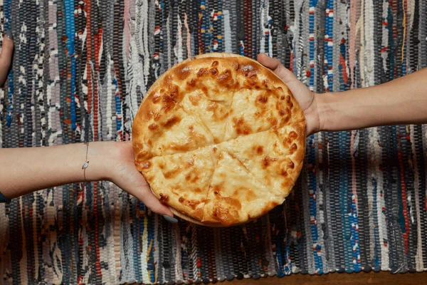 Khachapuri on the table. Top view female hand. — Stock Photo, Image
