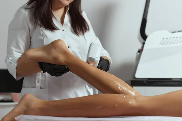 Young African woman getting laser hair removal on her thighs. — Stock Photo, Image
