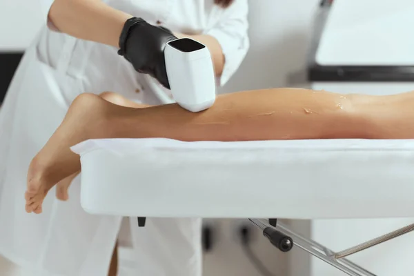 Young African woman getting laser hair removal on her thighs. — Stock Photo, Image