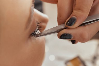 Kirpik uzatma yordamı. Kadın gözü ile uzun kirpiklerini. Kirpikler. Yakın, seçilen odak.