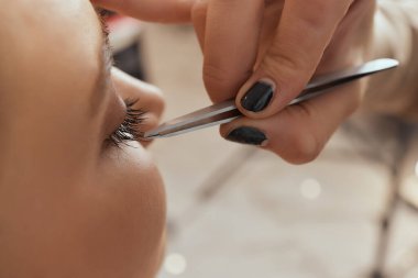 Kirpik uzatma yordamı. Kadın gözü ile uzun kirpiklerini. Kirpikler. Yakın, seçilen odak.