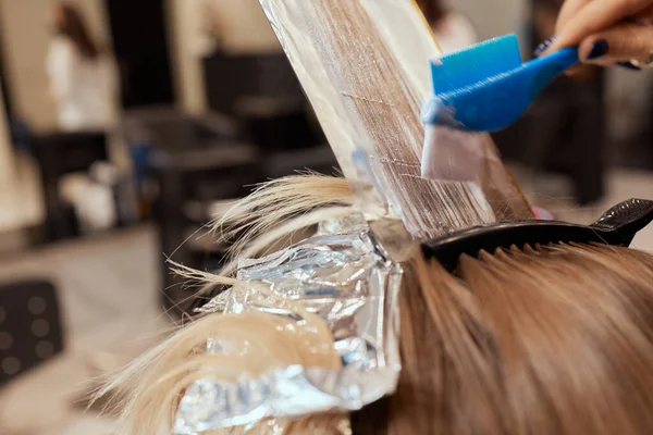 Haar stylist maakt bouffant met behulp van kam op dunne strengen. Shatush techniek voor het haar lichter. — Stockfoto