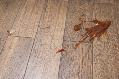 Kırık cam şişe parlak kırmızı domates sosu beyaz fayans zemininde, beyaz kağıt havlu rulosu, yukarıdan bakıldığında manzara, konsept kaza temizliği, mutfak pişirme.