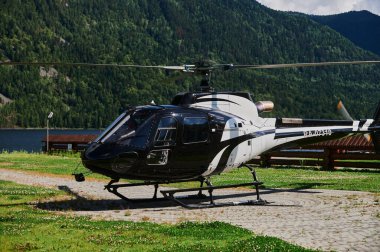 Altai Cumhuriyeti, Rusya - 05 Ekim 2021: Dağlara mavi bir helikopter iniyor. Şasi yerine kızaklar kullanılıyor..