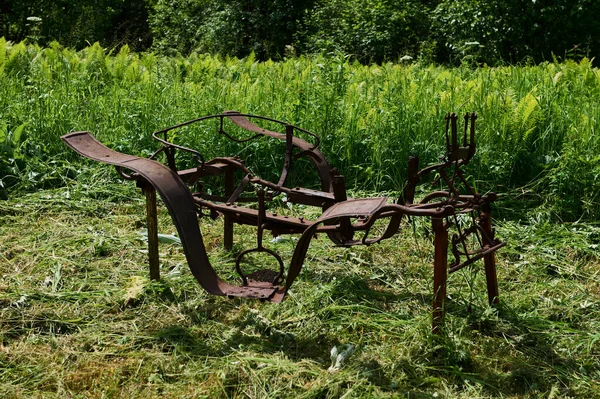 Old agricultural machinery. Old rusty plow on the edge of a agricultural field. — Photo