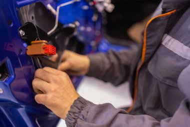Araba tamirhanelerindeki oto tamir teknisyenleri araba kapısı sistemlerini tamir ediyor ve elektrikli araç sistemlerini tamir ediyorlar..