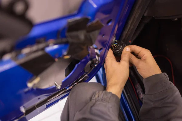 Auto repair technicians in car repair shops are repairing car door systems and repairing electric vehicle systems. — Foto de Stock