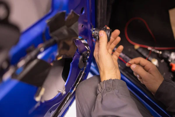 Auto repair technicians in car repair shops are repairing car door systems and repairing electric vehicle systems. — Foto de Stock