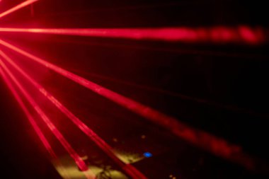 Parlak kırmızı neon lazer ışıkları karanlığı aydınlatır. Bilim kurgu efektiyle çizgiler ve üçgen şekiller yaratır..