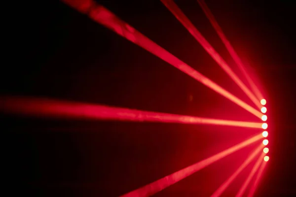 Bright red neon laser lights illuminate the darkness creating lines and triangle shapes in sci-fi effect. — Photo