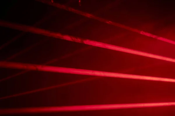 Bright red neon laser lights illuminate the darkness creating lines and triangle shapes in sci-fi effect. — Fotografia de Stock