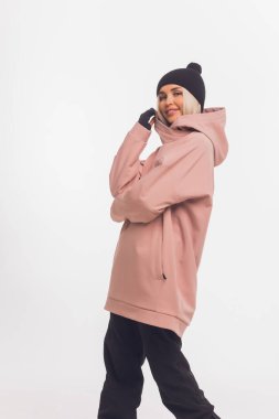 Kayakçı mutlu, beyaz, mutlu, gülümseyen 20 'li yaşlarda bir kadın, kalın bir rüzgarlık ceket giyiyor..