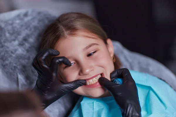 카프카스 출신의 어린 소녀가 의료용 의자에 앉아 치과에서 치과용 도구를 사용 해 치아를 치료하고 있습니다. 얼굴을 확대 한 사진이죠. 전문 의료 전문가. — 스톡 사진